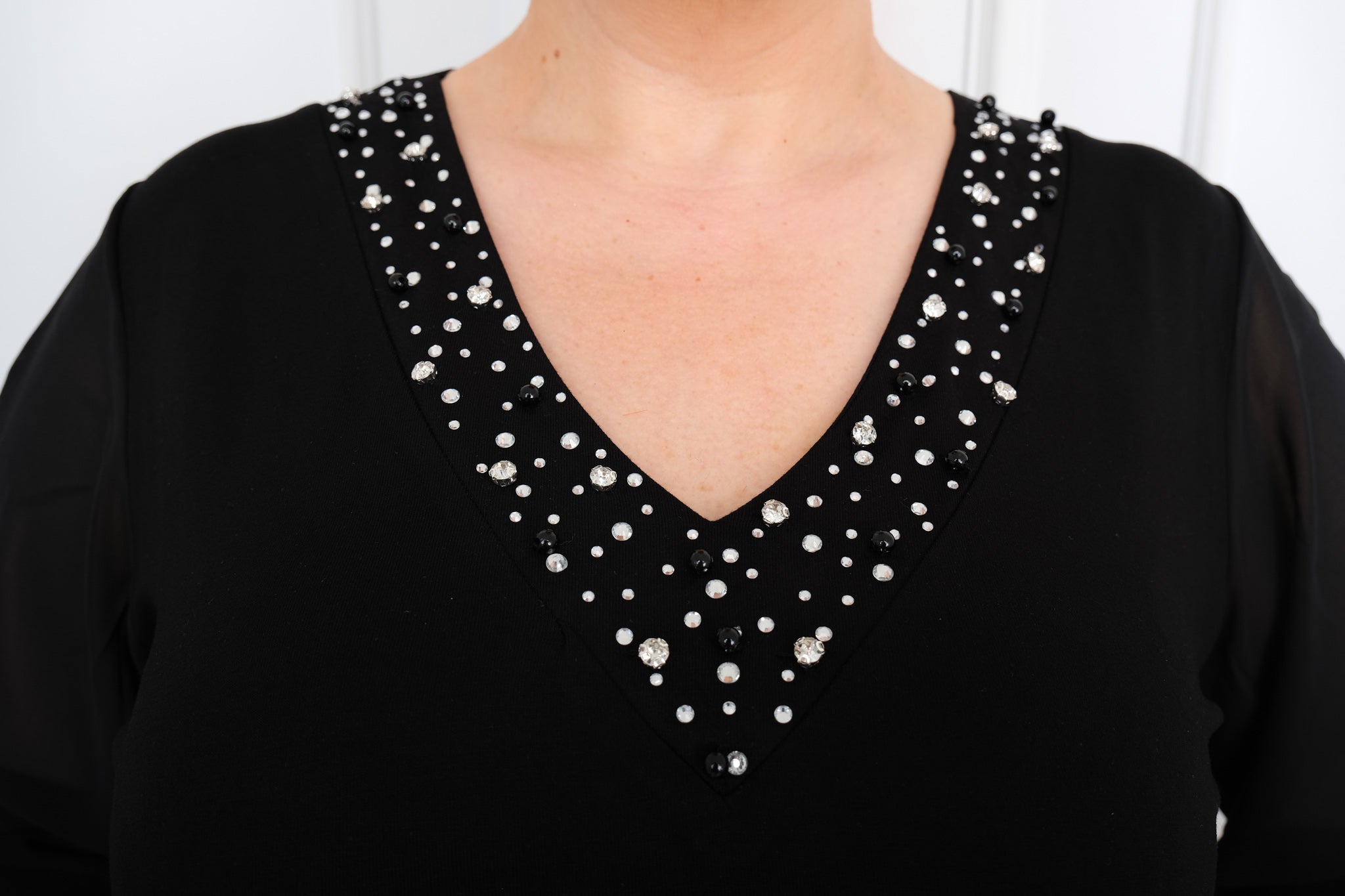 Dámské šaty s průsvitnými rukávy a kamínky ve véčkovém výstřihu